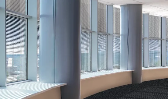 Eine lange gebogene Fensterfront mit metallischen Säulen.